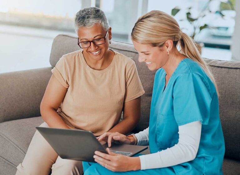 Family member and older adult share photos together in a comfortable assisted living room.